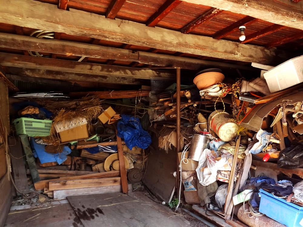 Cluttered wooden garage storing various old household items